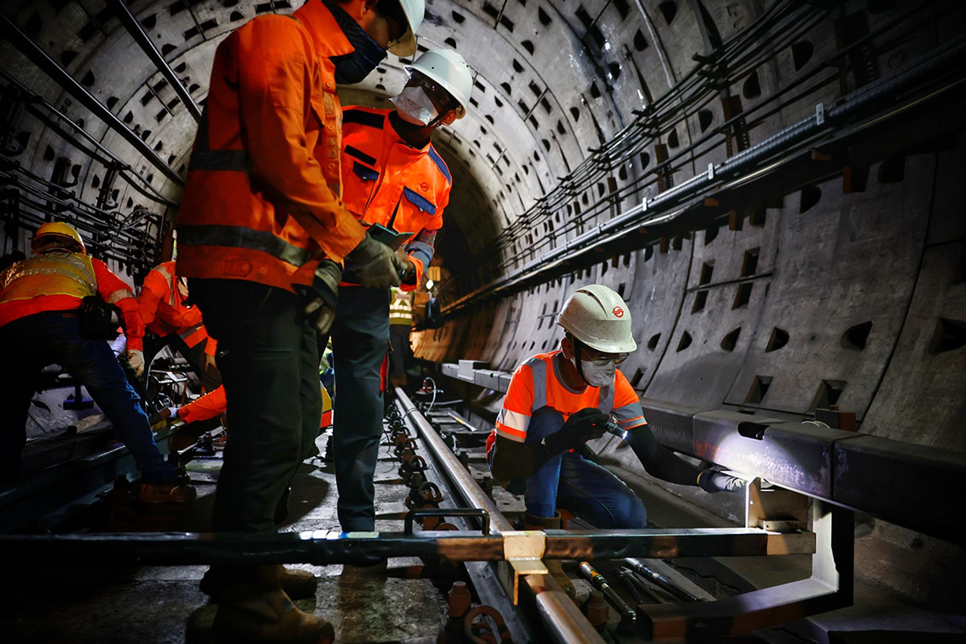 Workers measuring the distance between the running rail and the power rail, which supplies electricity to the track. Precision is key so that trains that run on the tracks can draw power. ST PHOTO: JASON QUAH