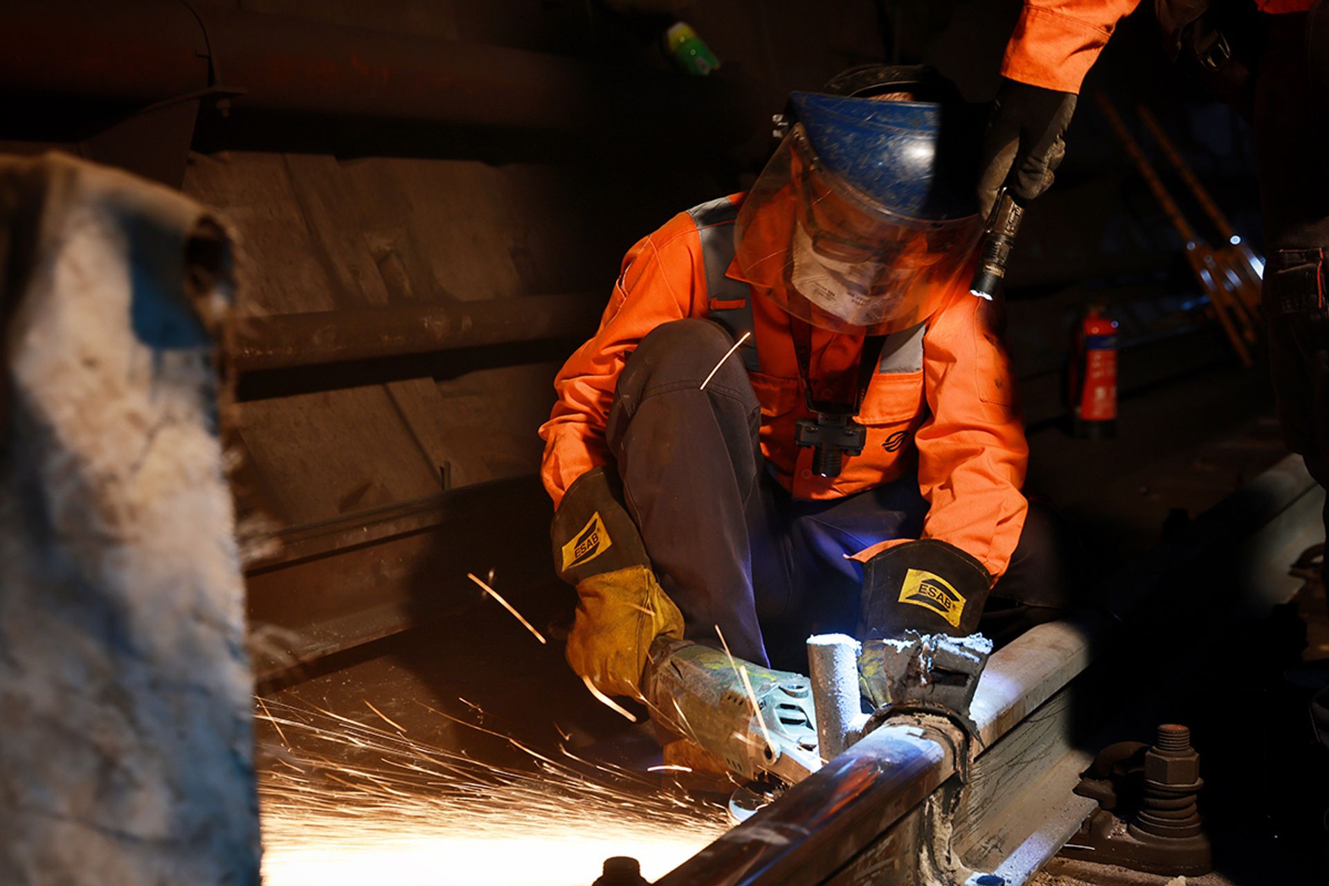 A worker carrying out profile grinding on the newly welded segment to smoothen the rail surface before train services begin. ST PHOTO: JASON QUAH