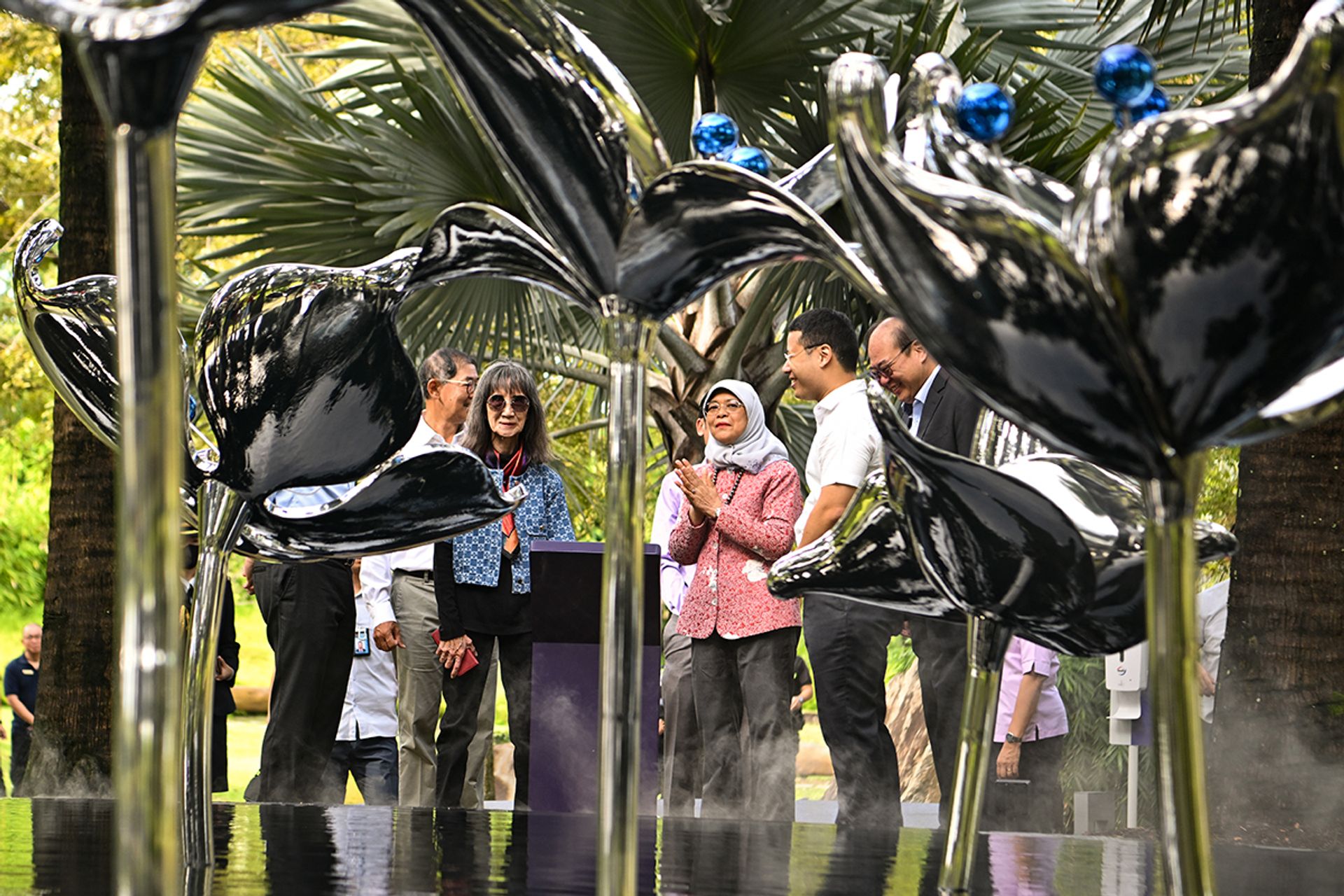 (From left) President Halimah viewing the Perpetual Blooms sculpture by Cultural Medallion recipient Han Sai Por (in sunglasses) with Minister for National Development Desmond Lee (second from right) and sculpture donor Tan Aik Hock (right) on Nov 9, 2022. The artwork commemorates Gardens by the Bay’s 10th anniversary. ST PHOTO: LIM YAOHUI