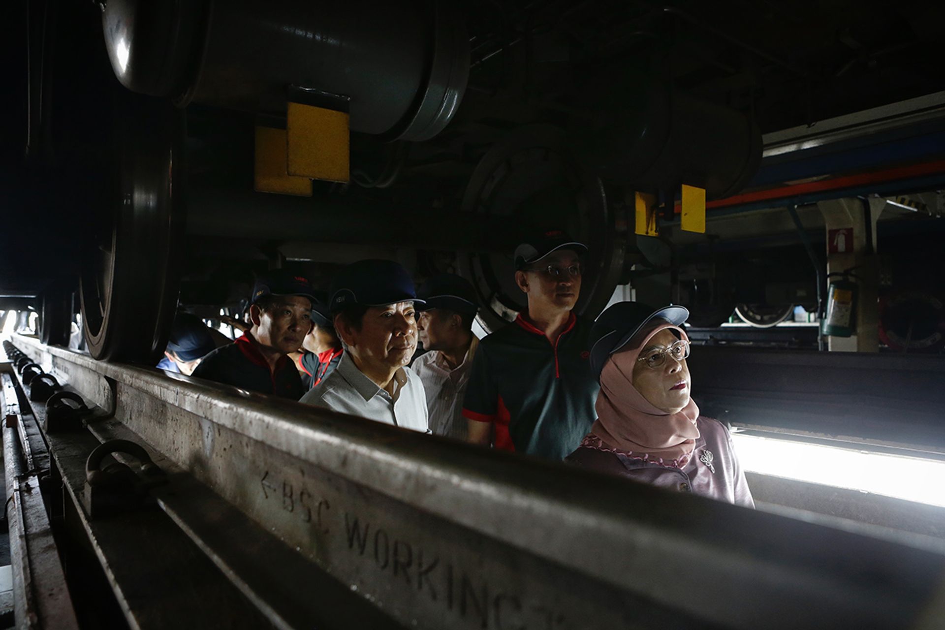 President Halimah observing maintenance work done on the undercarriage of a train from the maintenance pit during her visit to SMRT’s Bishan Depot on March 14, 2018. ST PHOTO: KEVIN LIM