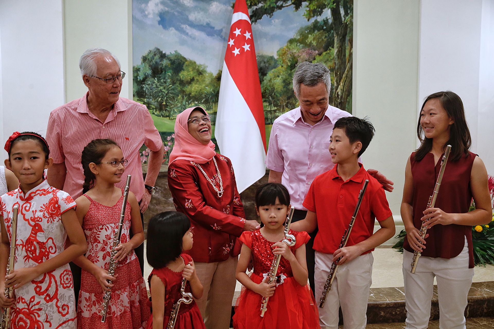 Emeritus Senior Minister Goh Chok Tong, President Halimah and Prime Minister Lee Hsien Loong sharing a light moment with young musicians (from left) Renee Koh, Nadia Chan, Beverley Ng, Yew Jing Yun, Joshua Yip and Olivia Yip during the National Day Observance Ceremony at the Istana on Aug 8, 2018. ST PHOTO: KEVIN LIM