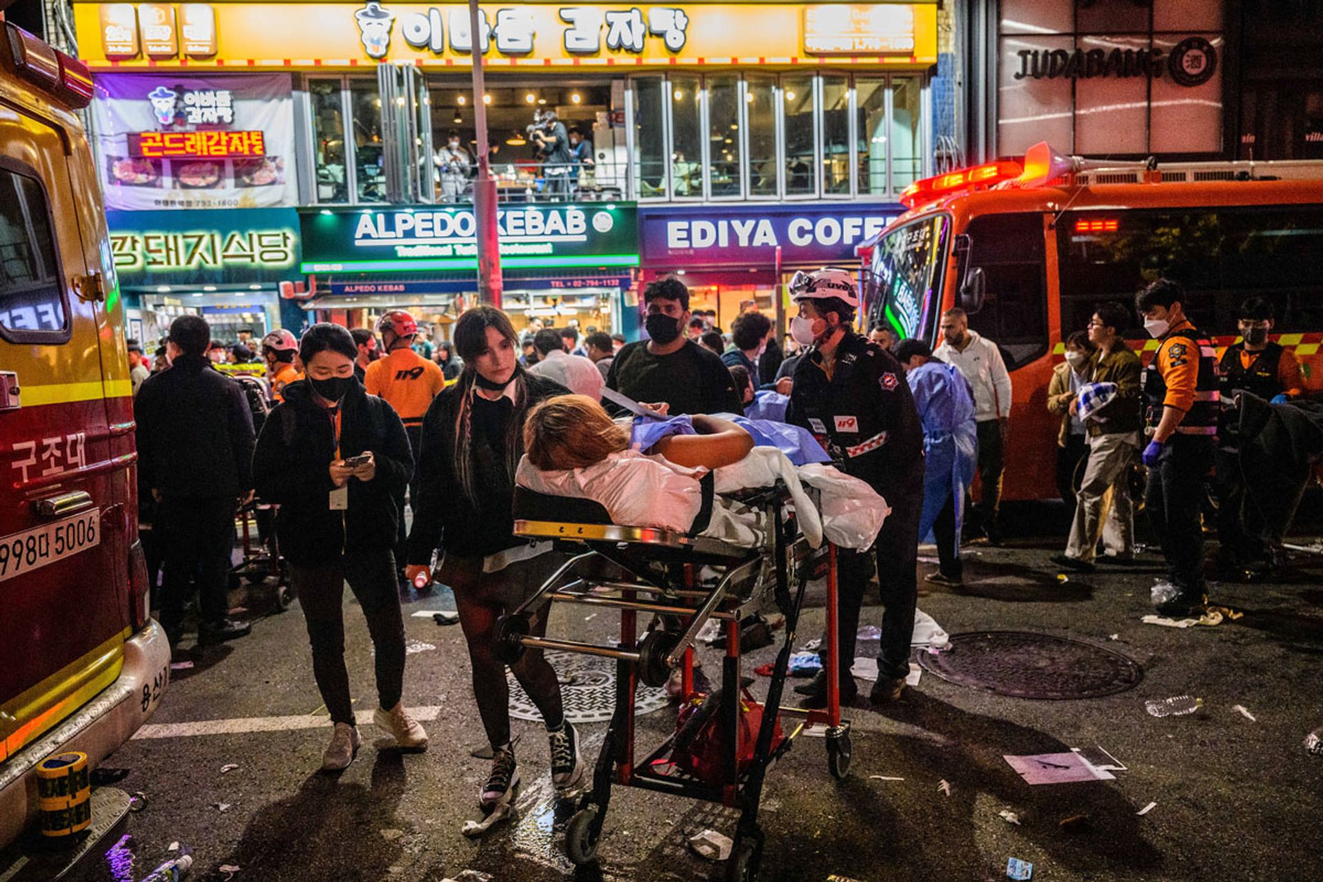 First responders helping an injured person on a stretcher  in the immediate aftermath of  the Oct 29 disaster in an Itaewon alleyway. PHOTO: AFP